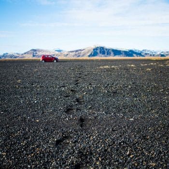 Photograph of a red car in the distance in Iceland