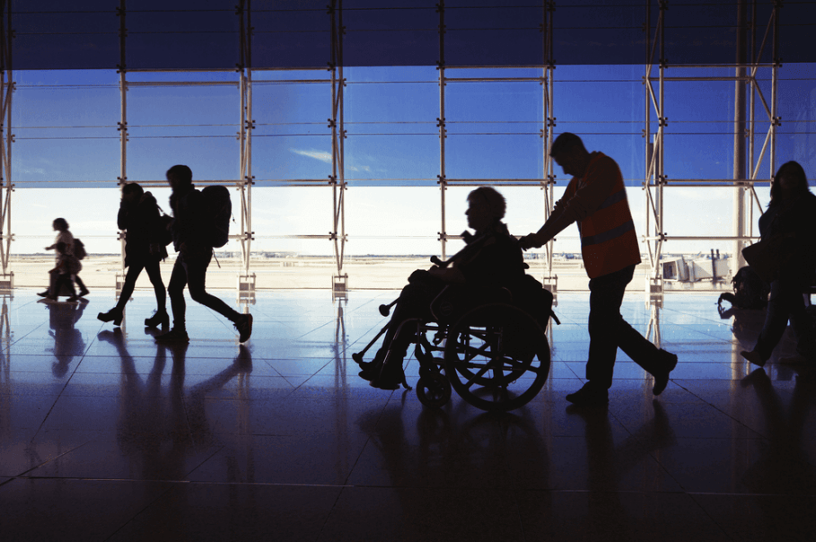 Photograph of a disabled passenger travelling through the airport, while using a wheelchair. 