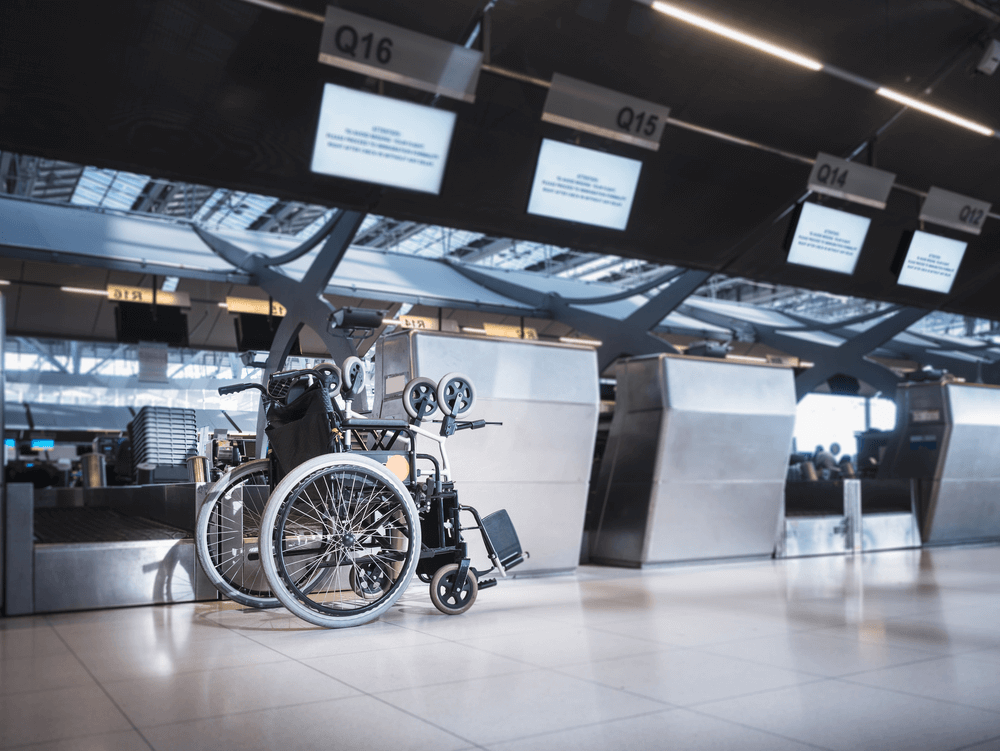 Wheelchair by check in desk at the airport. Why you should book special assistance when travelling with a disability