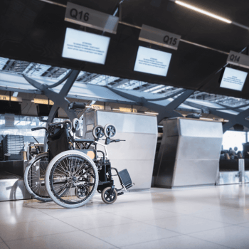 Wheelchair by check in desk at the airport. Why you should book special assistance when travelling with a disability