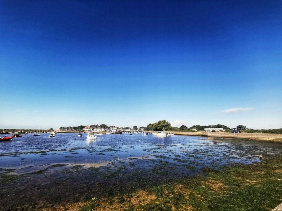 Boats moared at Keyhaven Marshes, with sunny blue clear skies.