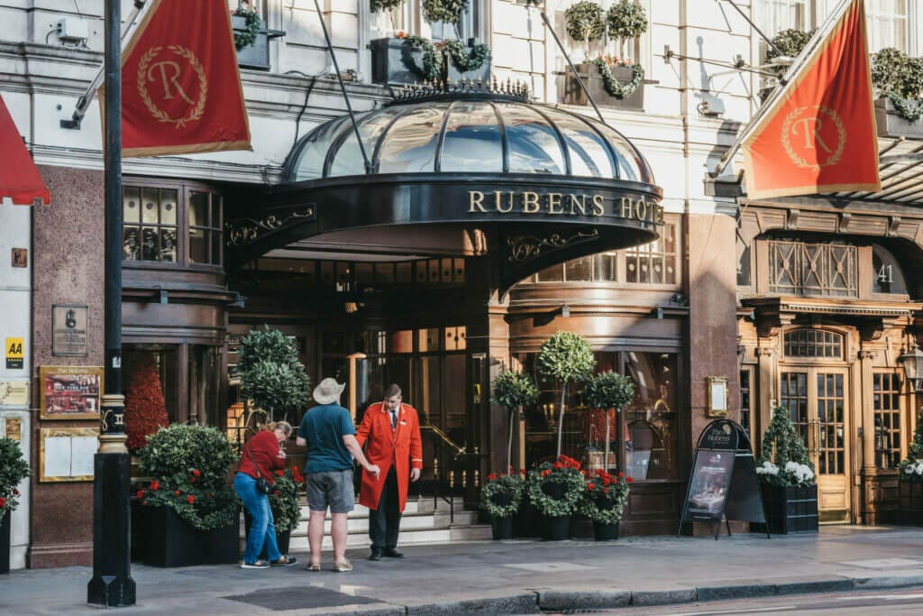 People talking to butler outside The Rubens at the Palace hotel