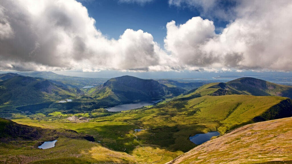 View over Snowdonia national park, with blue skies and fluffy white clouds