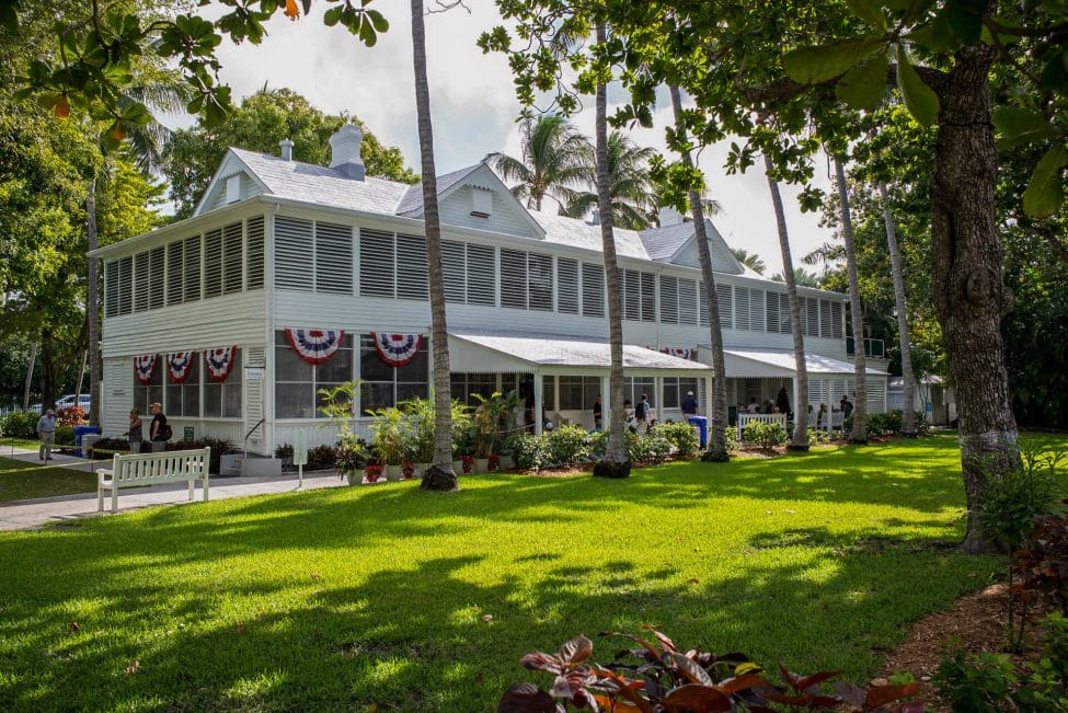 Photo of the outside of the Truman Little White House in Key West with red, white and blue banners flying.