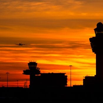 Plane arriving at Amsterdam-Schiphol airport during sunset