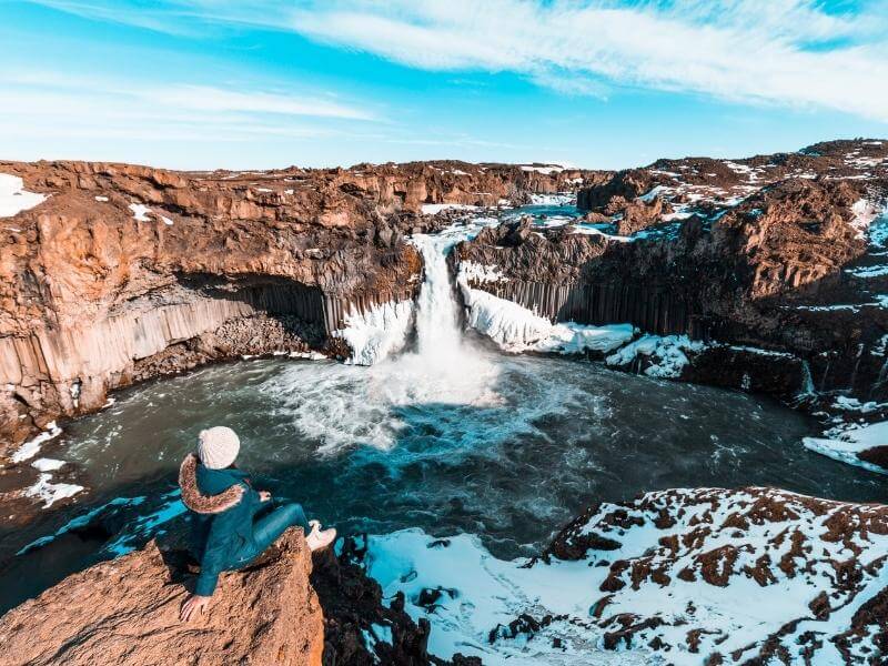 woman sat by Iceland godafoss waterfall