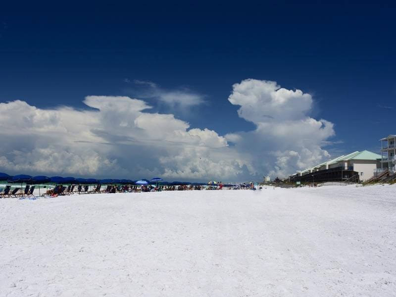 The beach at Okaloosa Island, with a cloudy blue sky.