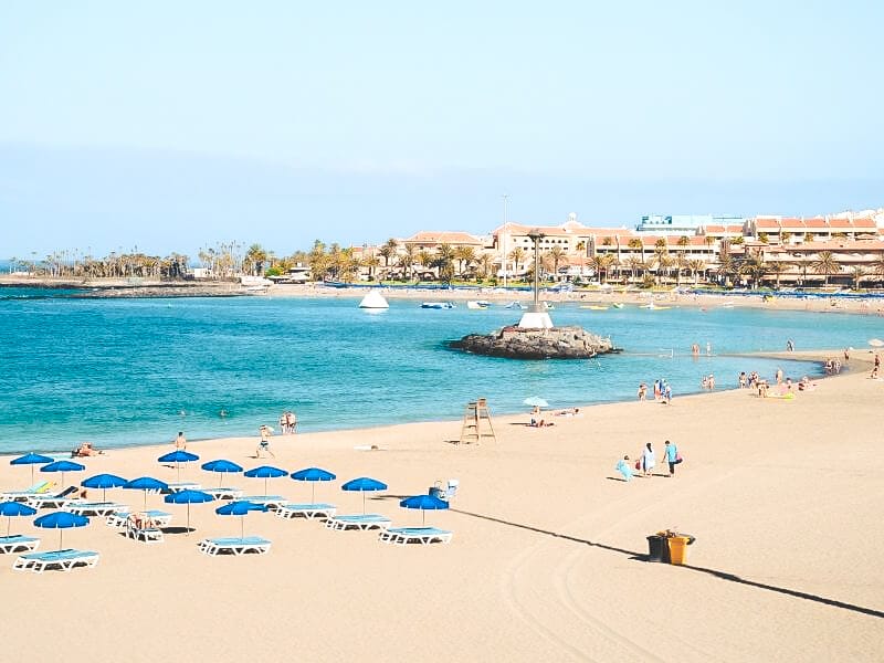 Las Vistas beach on a sunny day, with deckchairs on the sand and people sunbathing