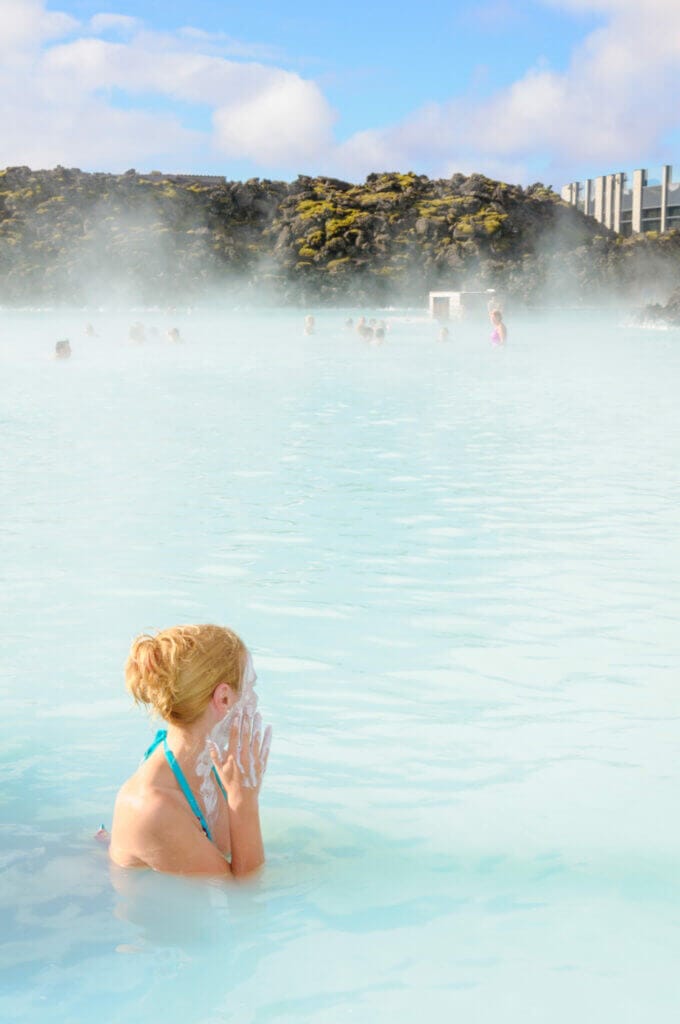 woman with blonde hair tied up in the blue lagoon in iceland