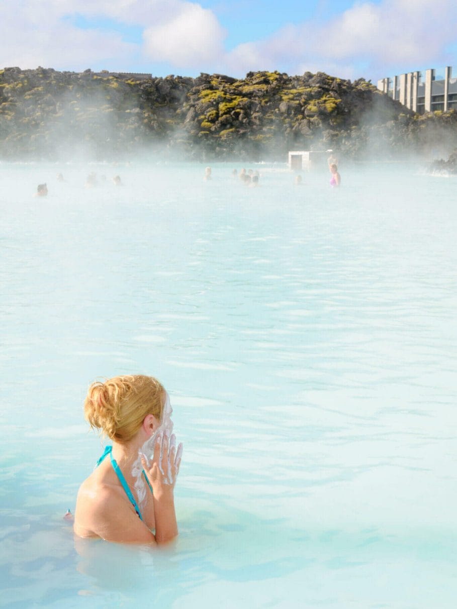 woman with blonde hair tied up in the blue lagoon in iceland