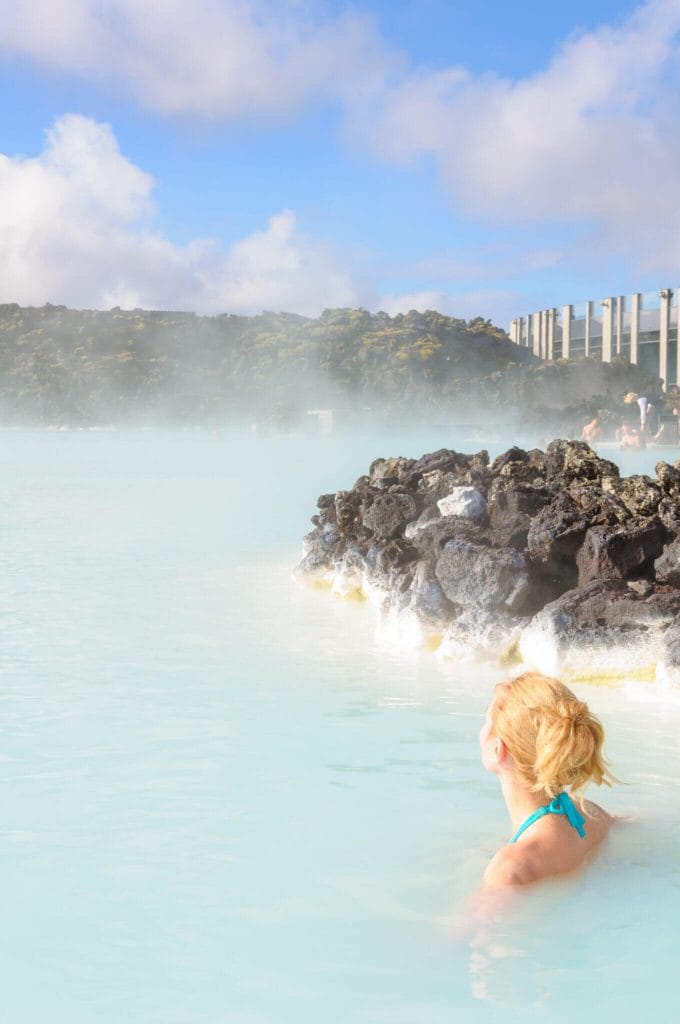 woman with blonde hair tied up in the blue lagoon in iceland