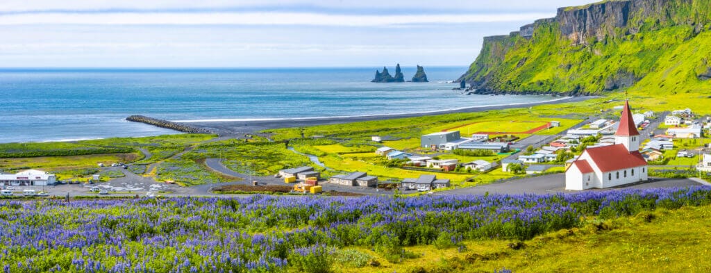 View of vik church, and the Reynisdrangar rock formations in Vik