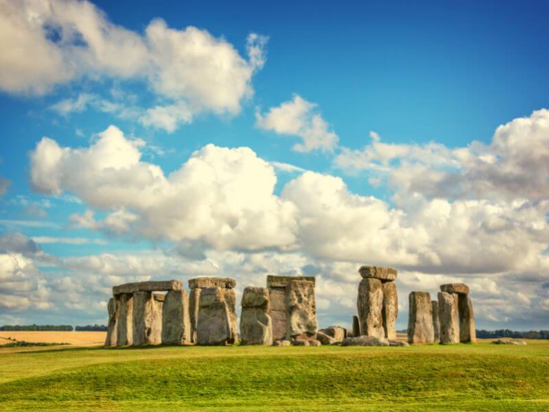 Stonehenge during the daytime with a blue cloudy sky