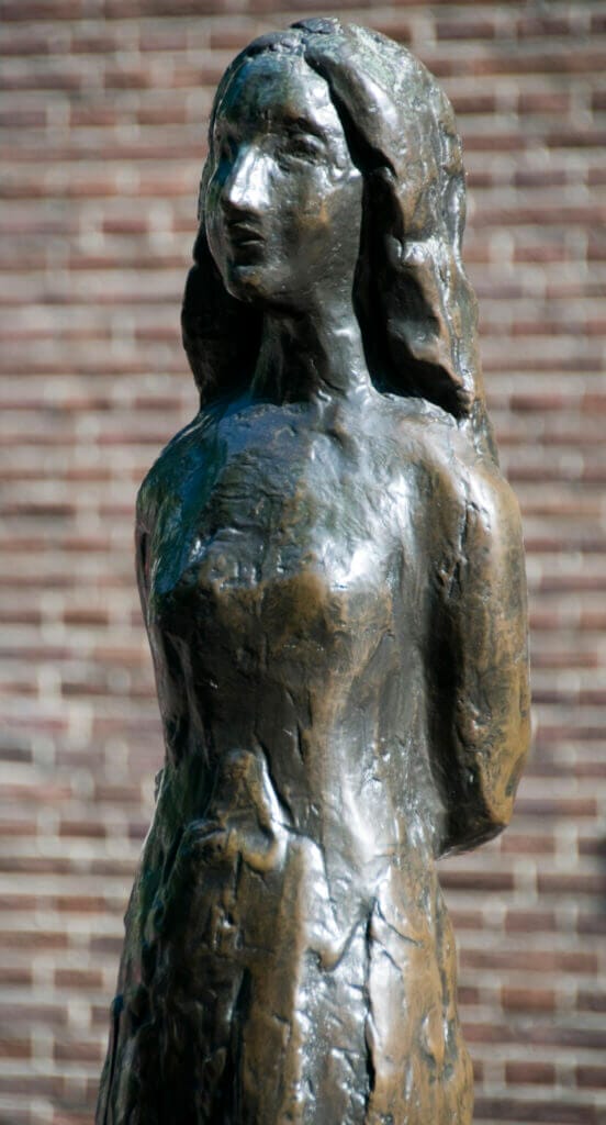 Statue of Anne Frank stands on Westerkerk plaza near the Anne Frank House amsterdam holland the netherlands