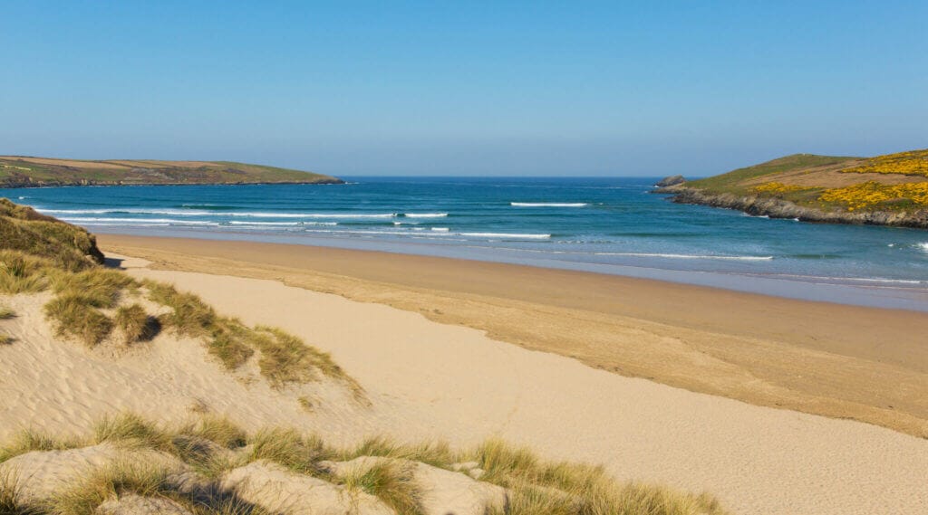 view across crantock beach towards the sea with blue sky