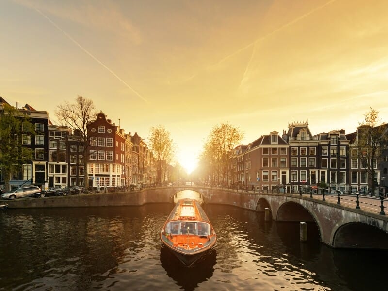 Photo of a lovers canal cruise company boat cruising along the waterways during sunset.