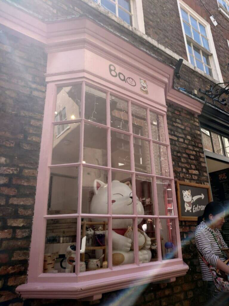 The front of Bao, which is part of the Meow and Bao chain. The hsop front is pink with a giant lucky cat sat in the window. 