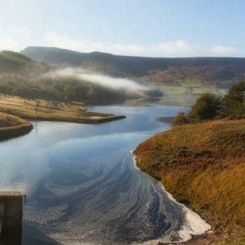 Spillway at the Dove stones reservoir with slightly mist and blue sky , Oldham, Saddleworth,