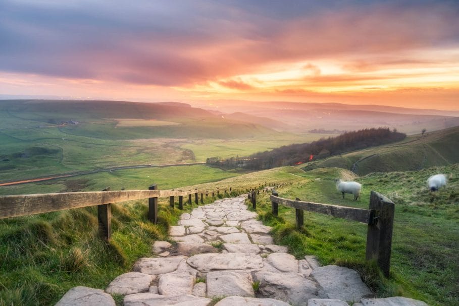 Morning sun casting golden light on the landscape at Mam Tor in the English Peak District.