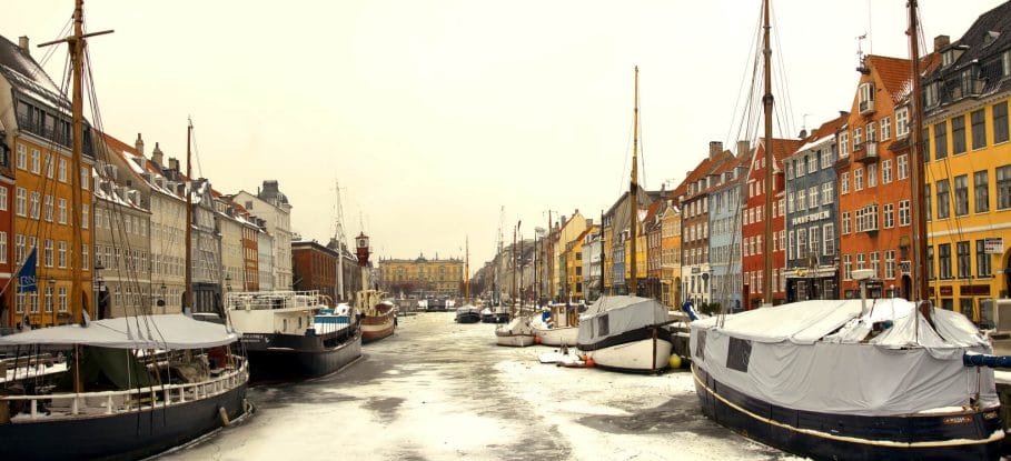 Nyhavn Canal in Winter with ships covered in snow.