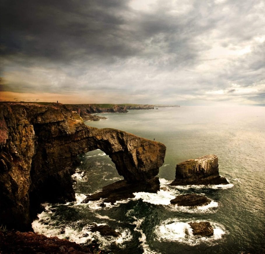 A high angle shot of the Green Bridge of Wales in the United Kingdom with a cloudy gray sky in the background