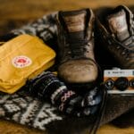 brown leather boots beside yellow fjallraven bag