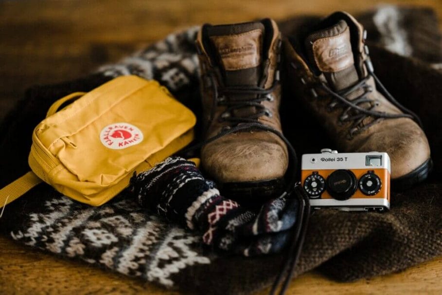 brown leather boots beside yellow fjallraven bag