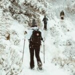 person in black jacket and black pants standing on snow covered ground during daytime